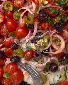 a salad with tomatoes, onions and olives