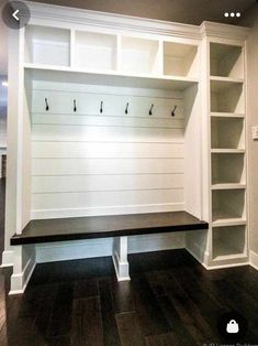 an empty bench in the middle of a room with built - in bookshelves