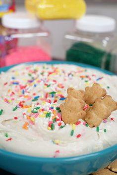 a blue bowl filled with white frosting and sprinkles