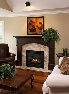 a living room filled with furniture and a fire place under a painting on the wall