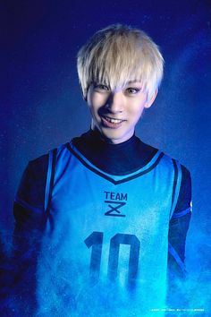 a young man with blonde hair wearing a blue uniform and posing for a photo in front of a dark background