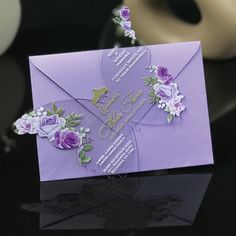 a purple card with flowers on it sitting on a table