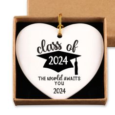 a white heart shaped ornament in a box with the words class of 202 printed on it