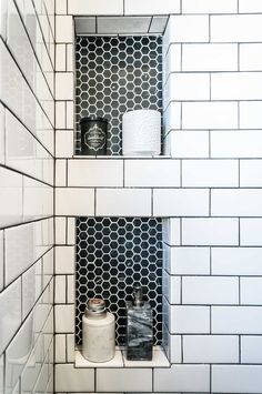 two black and white tiled shelves in the corner of a bath room with toiletries