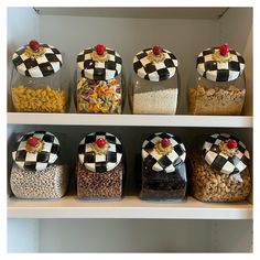 the shelves are filled with different types of snacks and cereals in glass containers on top of each other