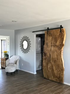 a living room filled with furniture and a large wooden door in the middle of it