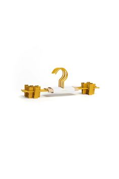 a white and gold object with a question mark on it's side, against a white background