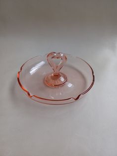 an empty glass plate with a heart on the top and bottom, sitting on a white surface