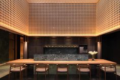 a dining room with a table and chairs in front of a wall made out of wood