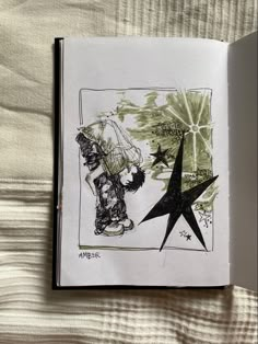 an open book with black and white ink drawings on the pages, featuring a star