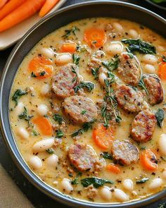 a bowl of soup with meatballs, carrots and spinach on the side