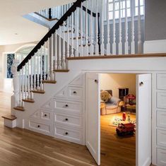 an open door leading to a living room with stairs and storage units in it,