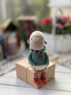 a small stuffed sheep sitting on top of a box