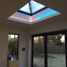 a living room with a skylight and sliding glass doors