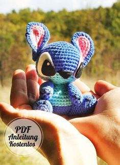 a hand holding a small crocheted stuffed animal