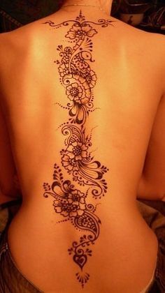 the back of a woman's body is decorated with intricate designs