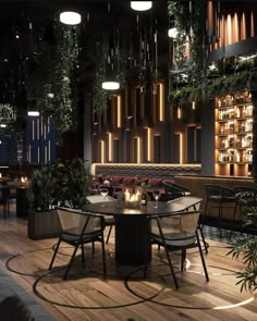 a restaurant with wooden floors and plants hanging from the ceiling, along with round tables