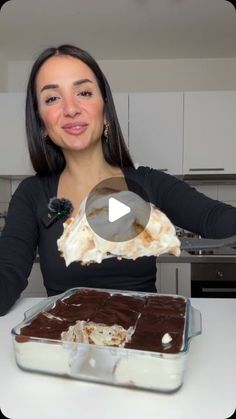 a woman is holding up a piece of cake