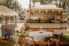 an outdoor food truck with tables and chairs