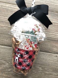 a cup filled with coffee and marshmallows on top of a wooden table