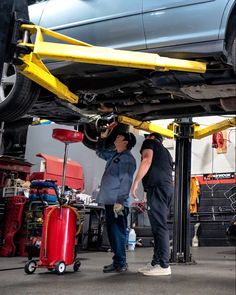 two men working on the underside of a car