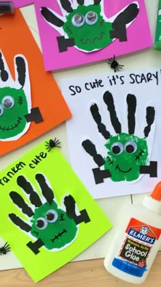 some handprints are on the table next to paint and glue for halloween crafts