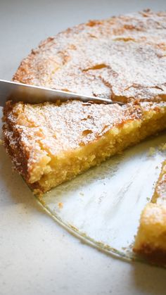 a close up of a cake on a plate with a slice cut out and a knife stuck in it