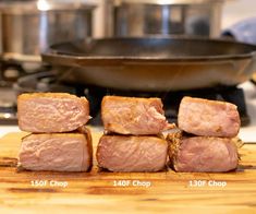 four pieces of meat sitting on top of a wooden cutting board