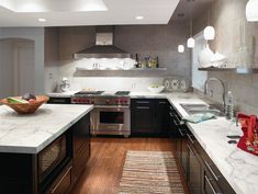 a modern kitchen with marble counter tops and stainless steel appliances