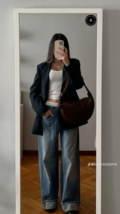 a woman taking a selfie with her cell phone in front of an empty room