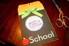 a pair of scissors sitting on top of a wooden table next to a school bag