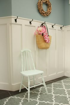 a white chair sitting next to a wall with a purse hanging on it's back