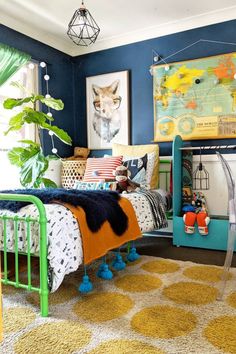 a bedroom with blue walls, yellow and white rugs and pictures on the wall