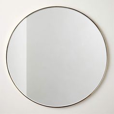 a round mirror on the wall with no one around it in front of white background