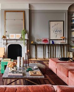 a living room filled with furniture and a fire place in front of a mirror on the wall