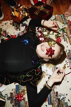 a woman laying on top of a rug covered in confetti