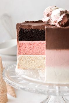 a slice of cake on a glass plate with ice cream cones in the back ground