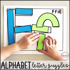 a child's hands on top of a piece of paper with the letters e and f