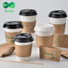 several coffee cups with lids and paper wrappers