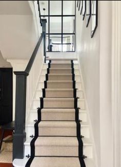 the stairs are lined with black and white carpet