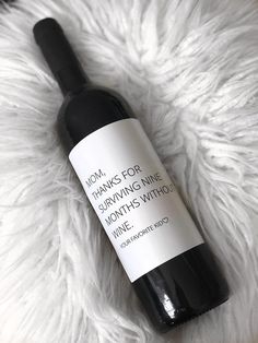 a bottle of wine sitting on top of a white fur covered floor next to a pen