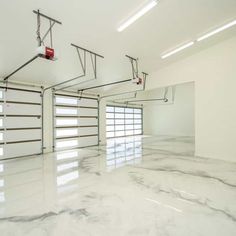 an empty garage with white marble flooring and overhead lighting on either side of the garage door