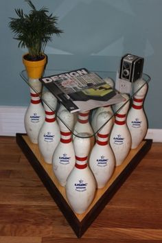 there is a bunch of bowling pins and a magazine on top of the ball stand