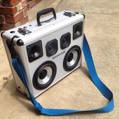 a suitcase with speakers attached to it sitting on the ground