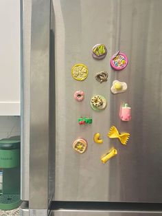 a refrigerator with magnets on the door and various food items hanging from it's side