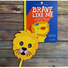 a lion mask and book on a wooden table