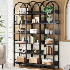 a living room filled with furniture and a book shelf next to a couch in front of a window