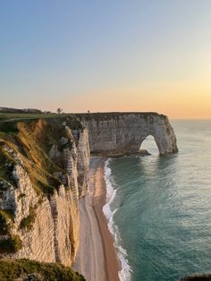 an image of the beach and cliffs at sunset