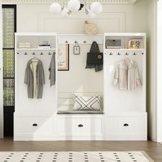 an entryway with white cabinets and coat racks