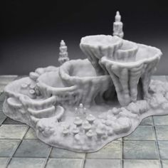 a small white sculpture on top of a tile floor